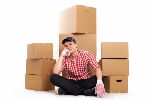 Movers carrying furniture through a Camden flat staircase